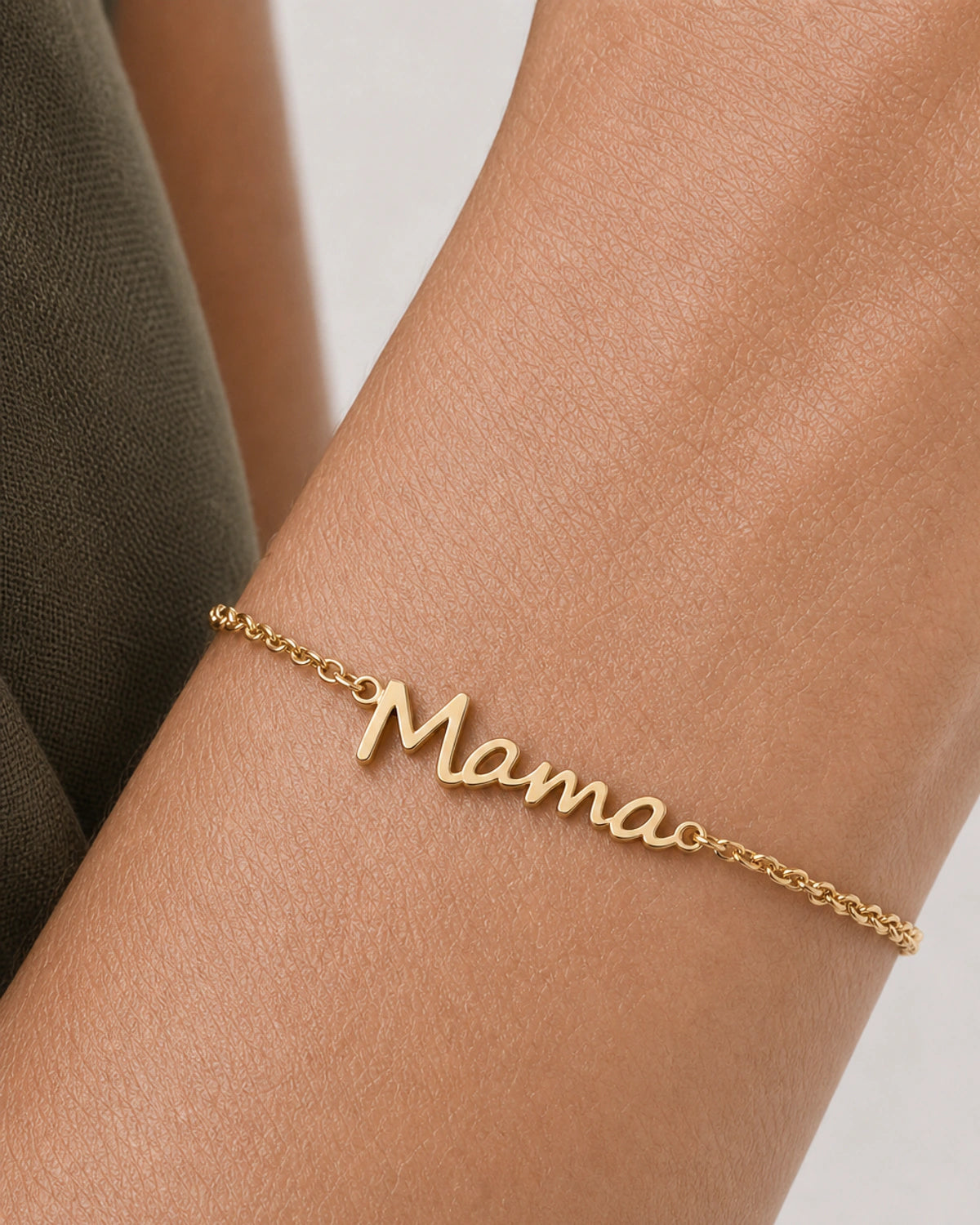 Extreme on-wrist macro of the Sera gold Mama script and fine chain