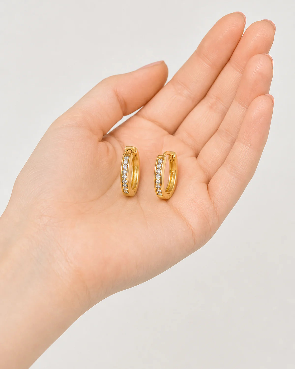 Hand-held scale view of the Serein pave huggie pair