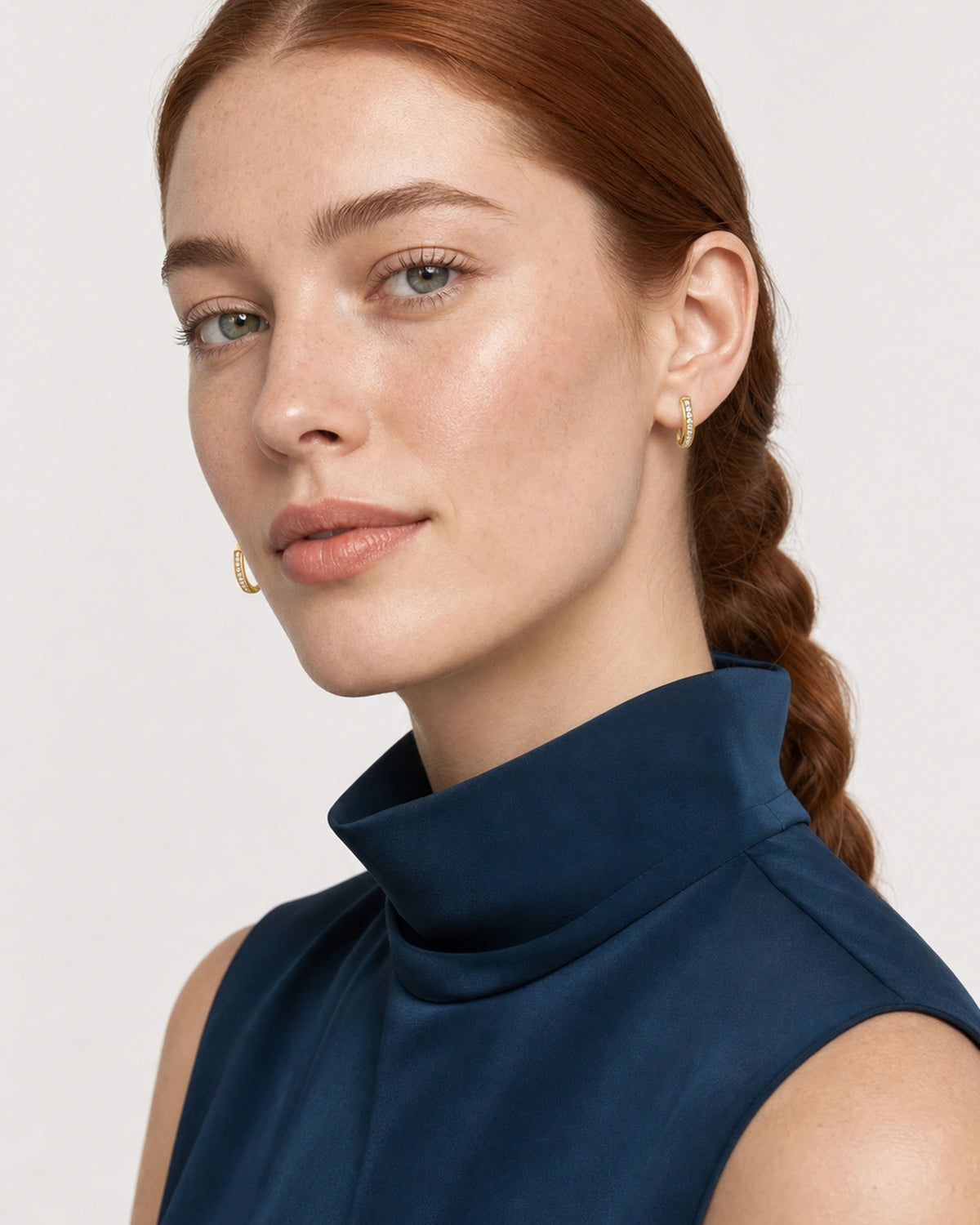 Face portrait wearing the Serein gold single-row pavé huggies