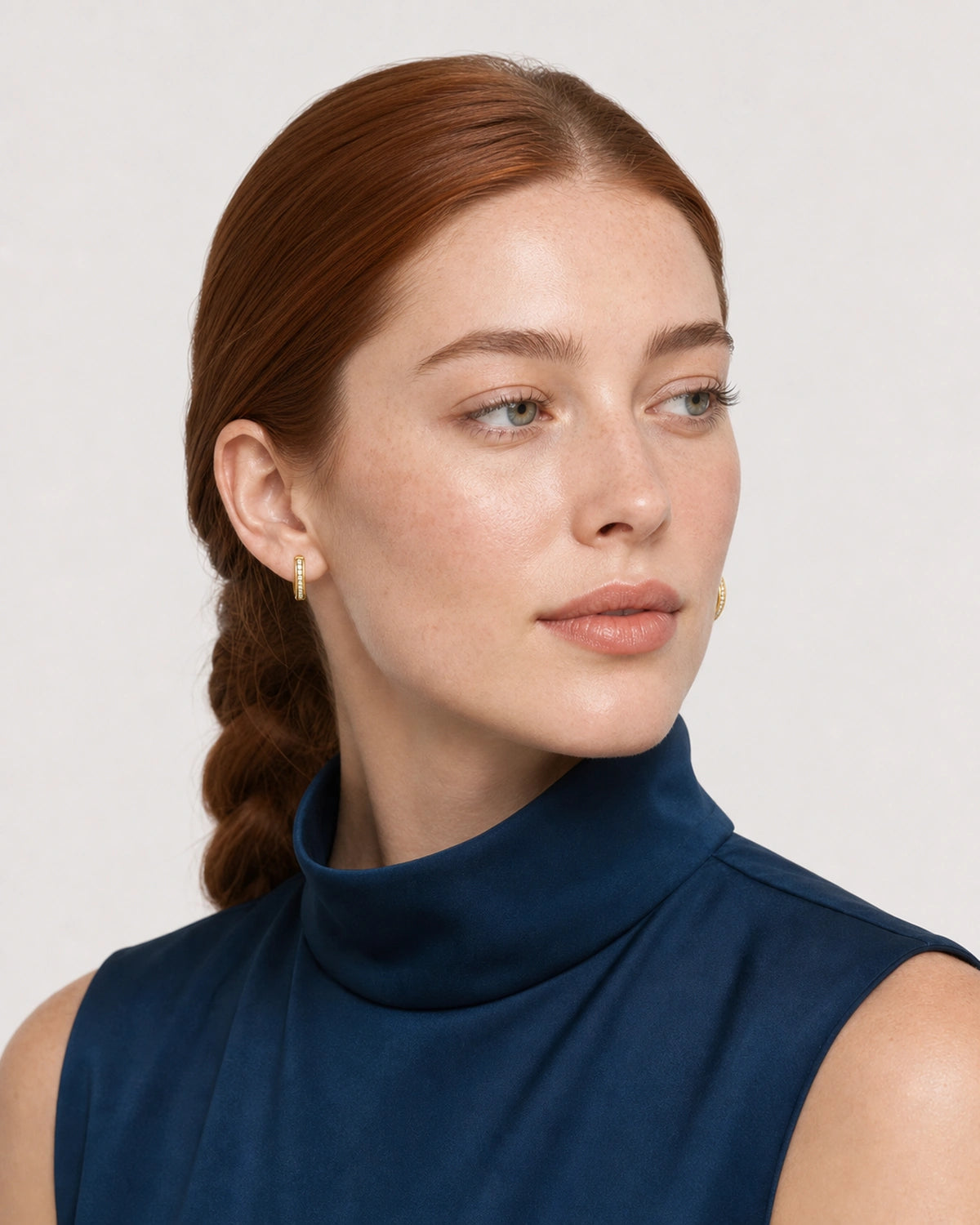 Alternate face portrait wearing the Serein gold single-row pavé huggies