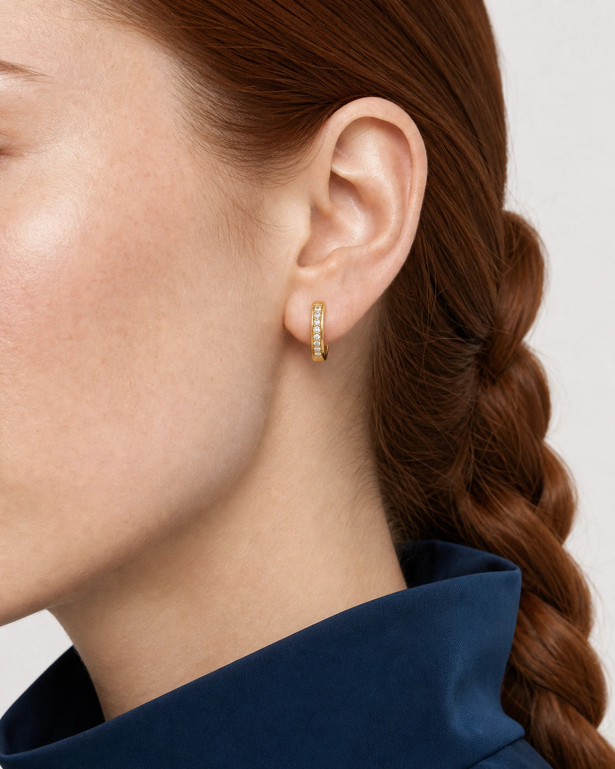 Tight right-ear and jawline view of the Serein gold pavé huggie