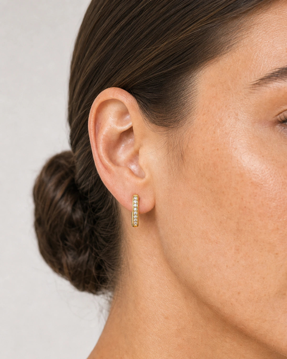 Close on-ear view of the compact Serein single-row pave huggie