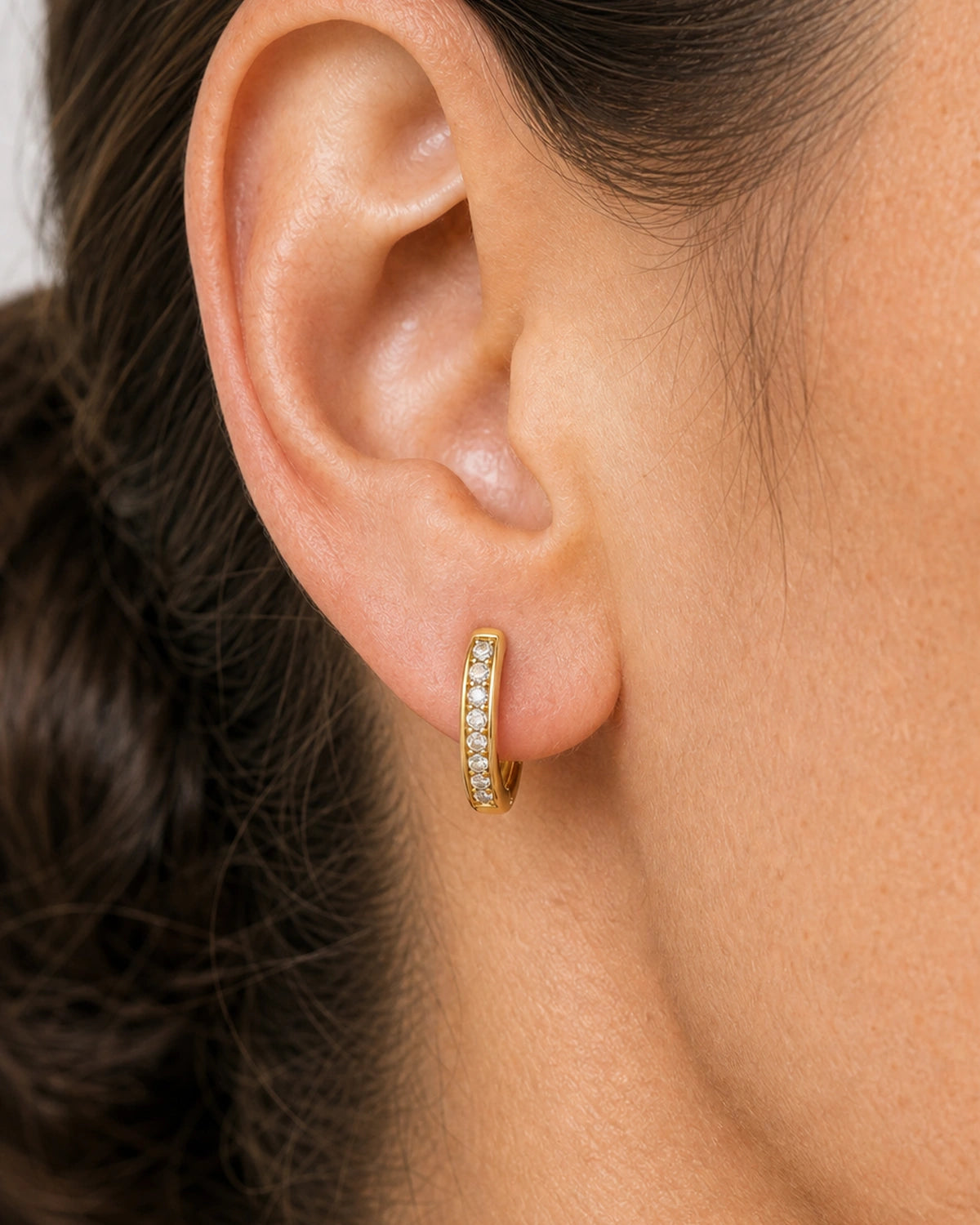 Extreme on-ear macro of the Serein pave row, hoop curve and hinge