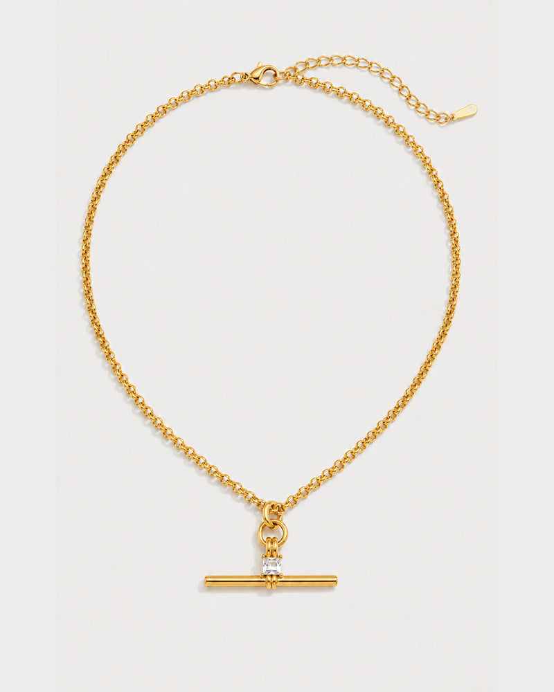 Sloane gold crystal toggle necklace on a pale dove-grey background