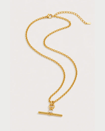 Sloane gold-tone toggle necklace in an alternate curved arrangement on pale grey