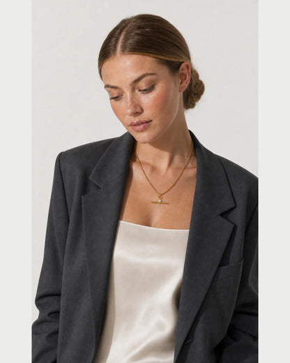 Three-quarter portrait of model looking down at the Sloane crystal necklace