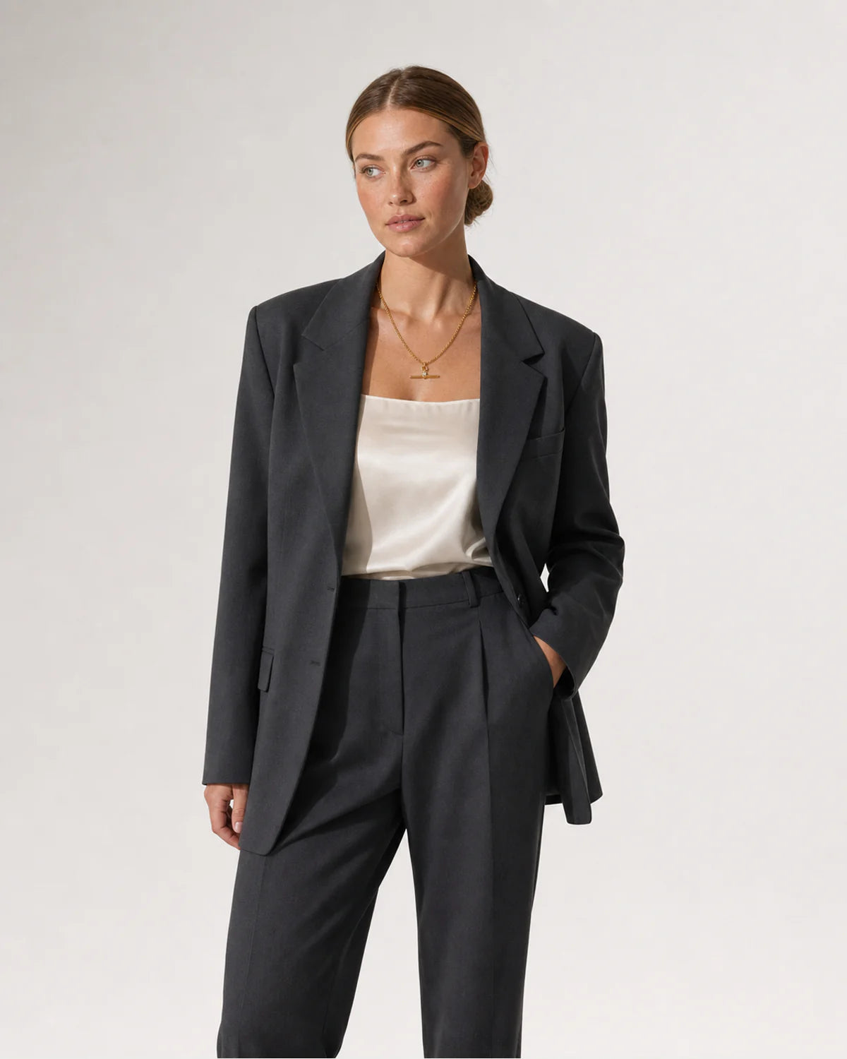 Wide grey-studio editorial portrait featuring the Sloane toggle necklace