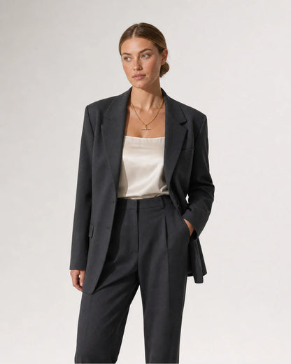 Wide grey-studio editorial portrait featuring the Sloane toggle necklace