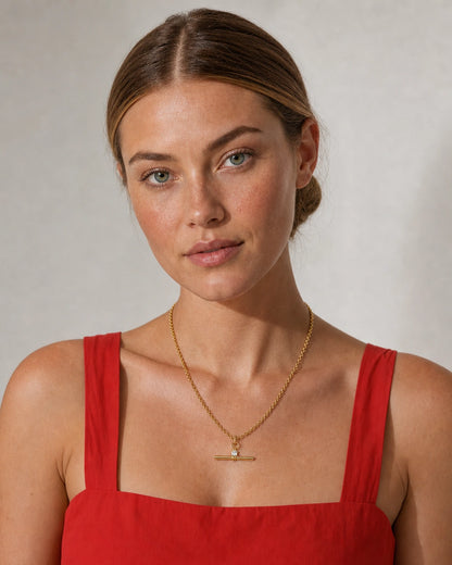 Brunette model in a red summer sundress wearing the Sloane crystal toggle necklace