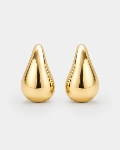 Solène gold sculpted teardrop stud earrings on pale dove-grey