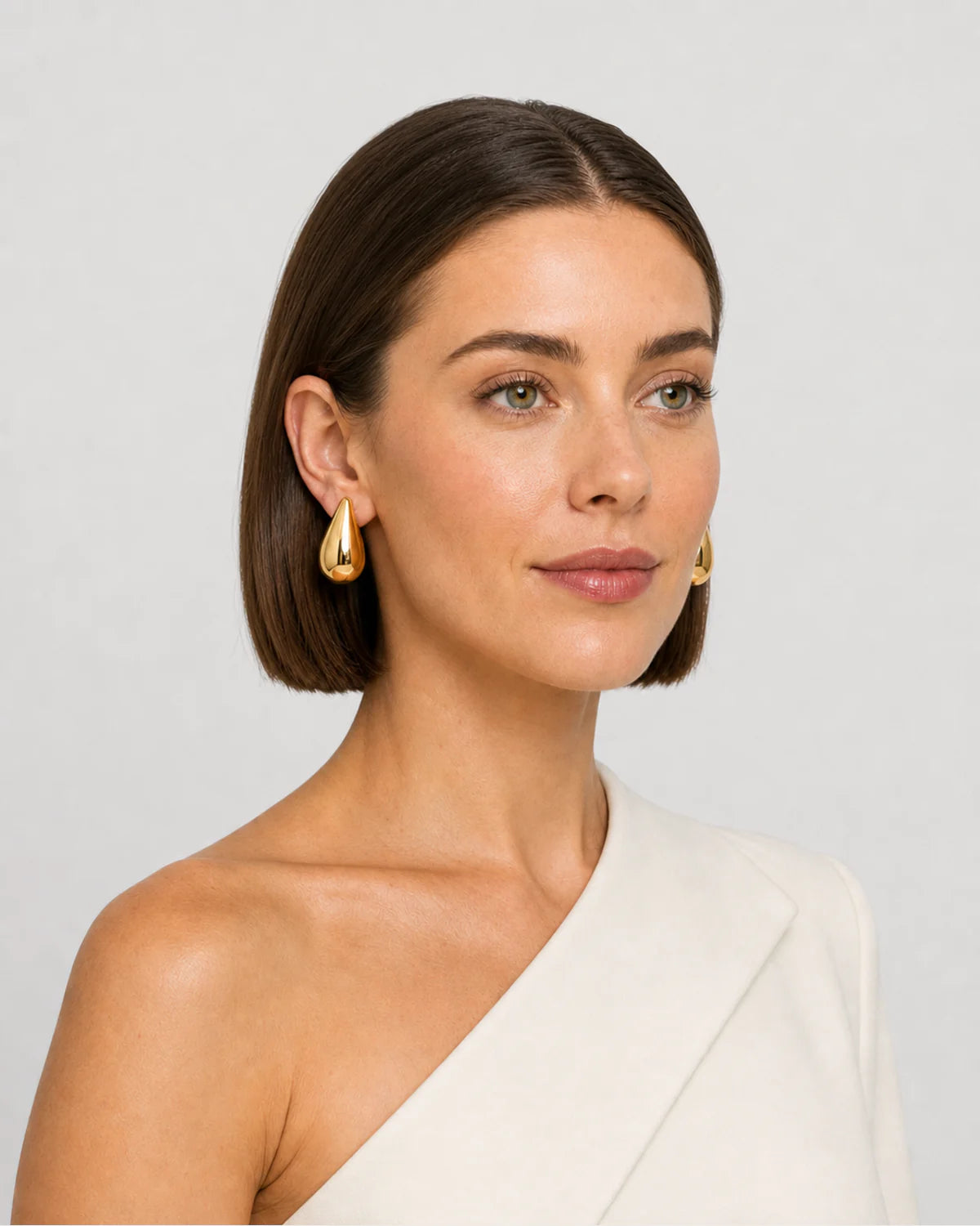 Three-quarter studio portrait featuring the Solène gold earrings