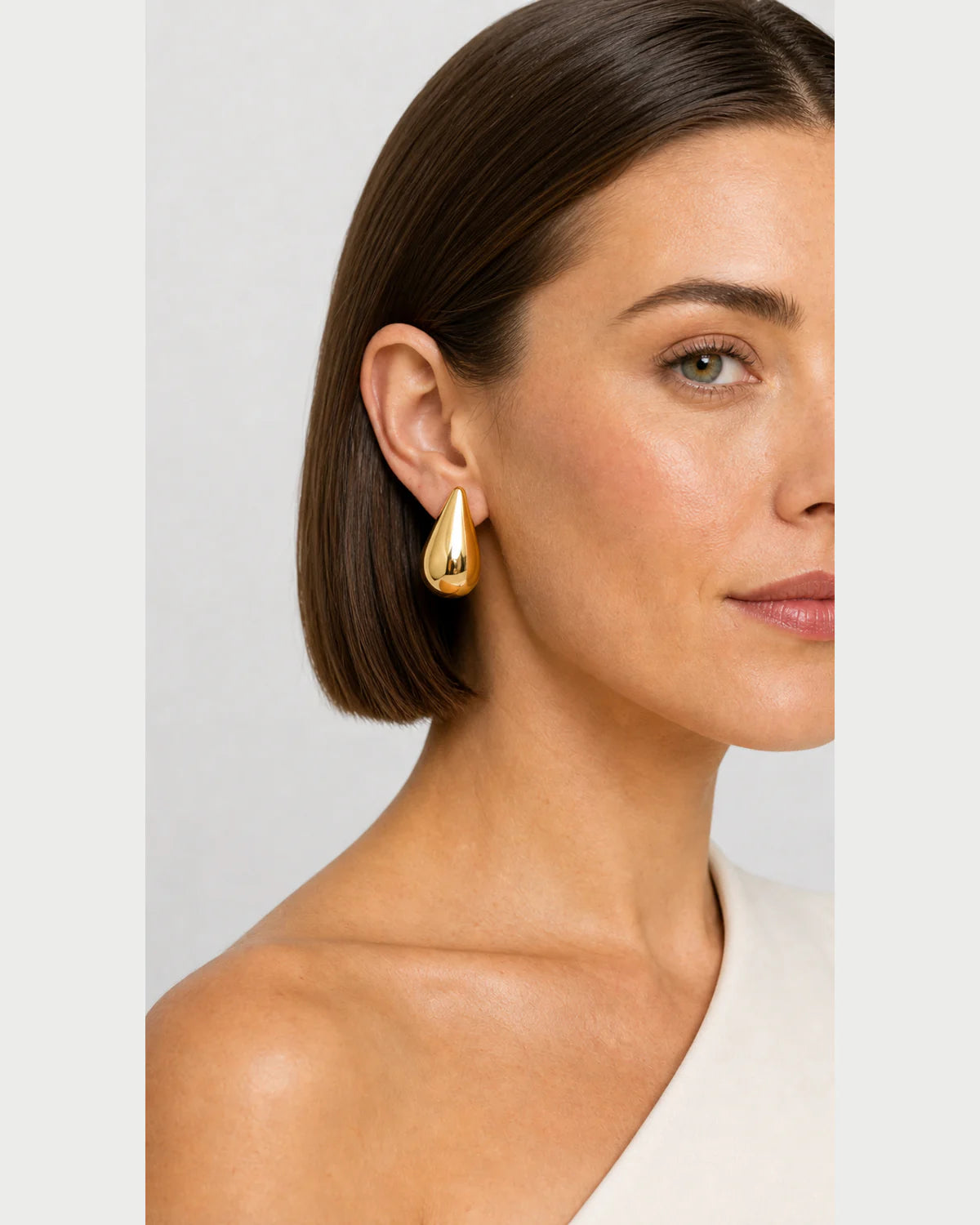 Close side portrait showing the Solène gold teardrop stud
