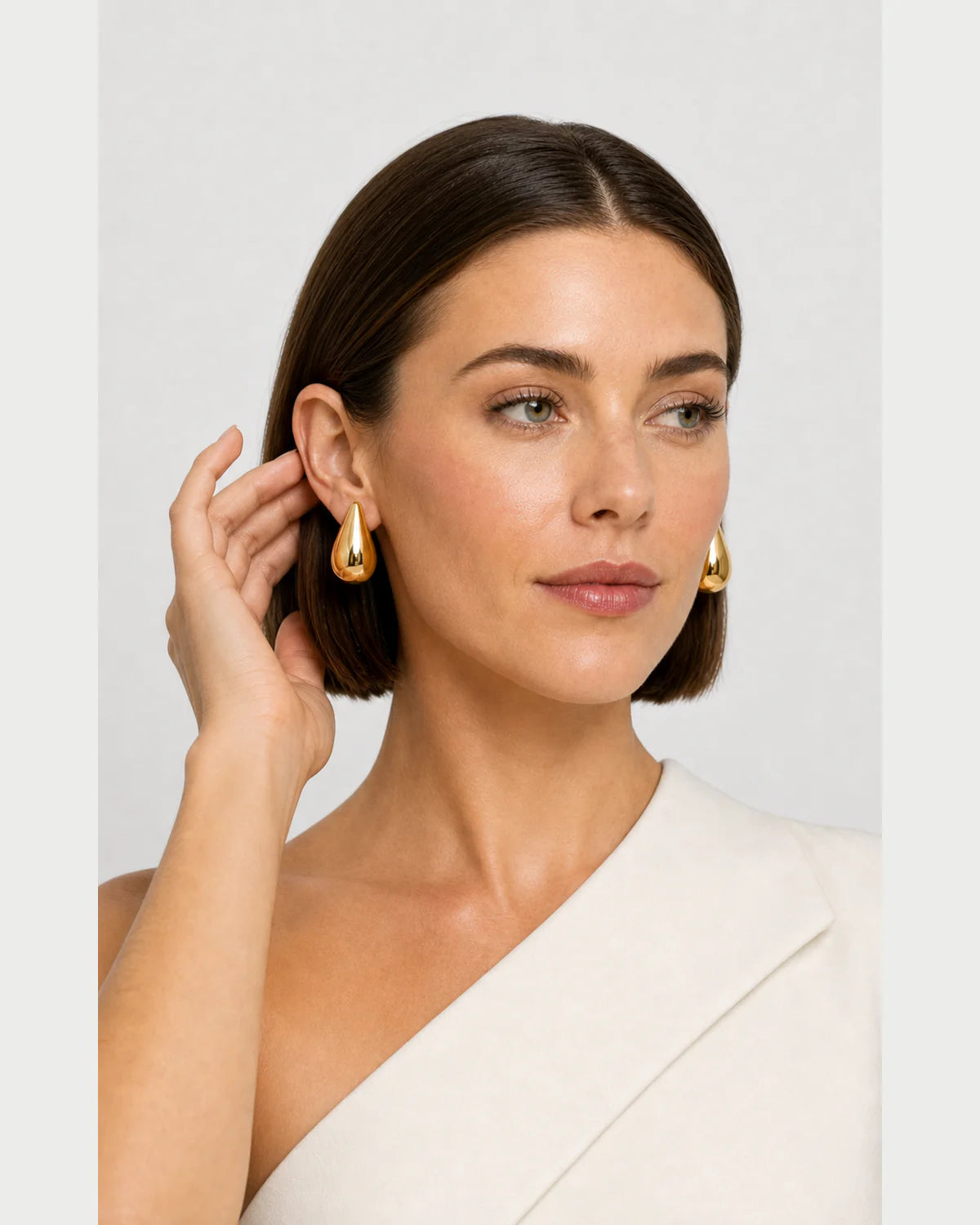 Human-scale portrait with a hand gesture beside the Solène earring