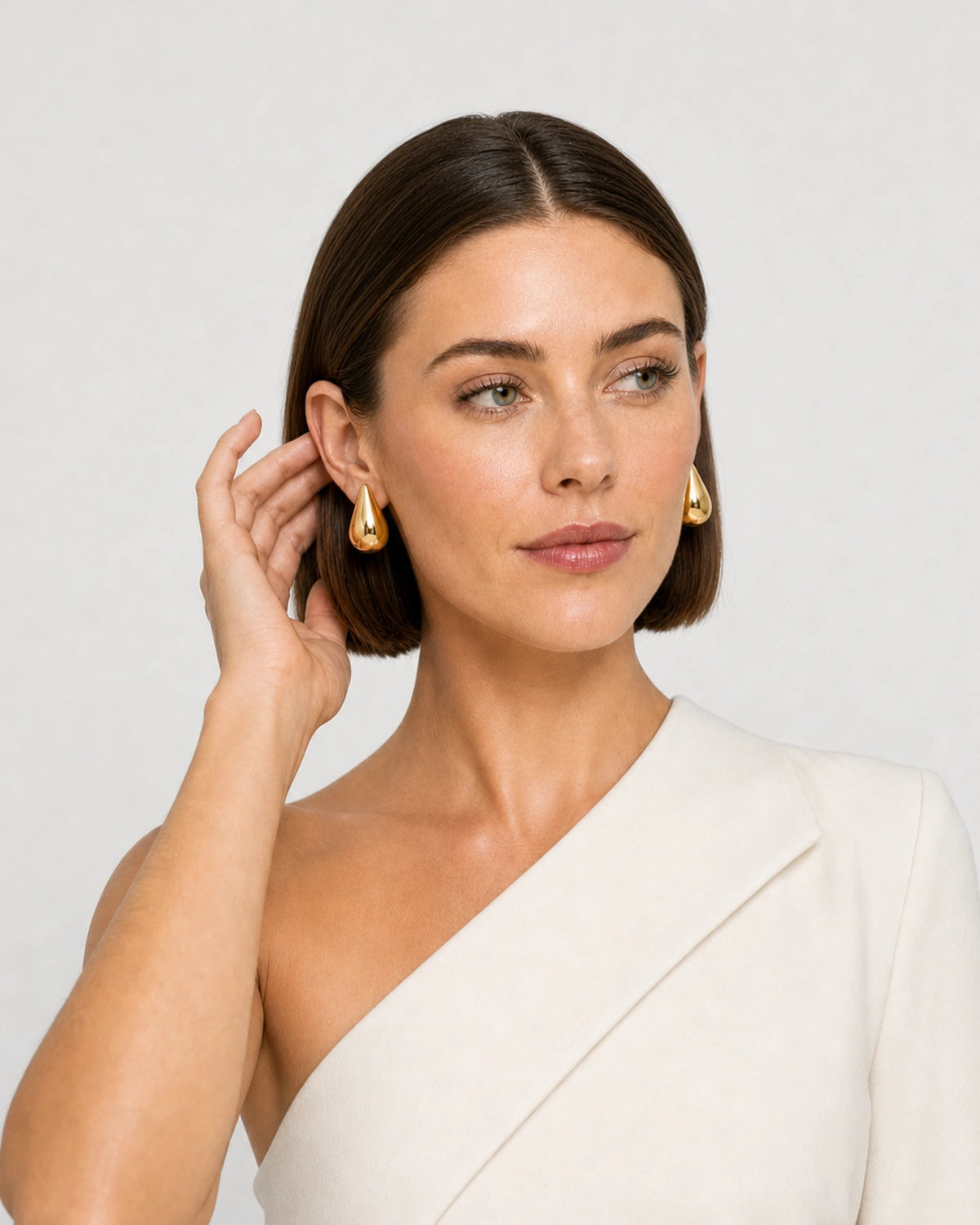 Human-scale portrait showing the sculpted Solène gold teardrop earrings