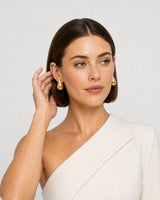 Human-scale portrait showing the sculpted Solène gold teardrop earrings