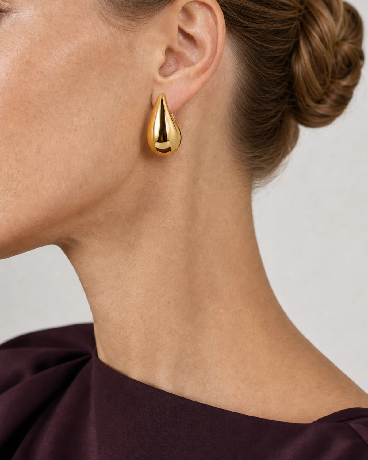 Eye-free left profile of Lydia wearing the gold Solène teardrop earring