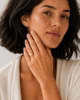 Australian model aged 24 to 28 wearing the Solenne A signet ring in a pale dove-grey studio