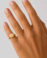 Clean on-hand close-up of the Solenne oval signet engraved with A