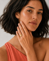 Model in a coral Positano silk top wearing the Solenne A initial signet ring