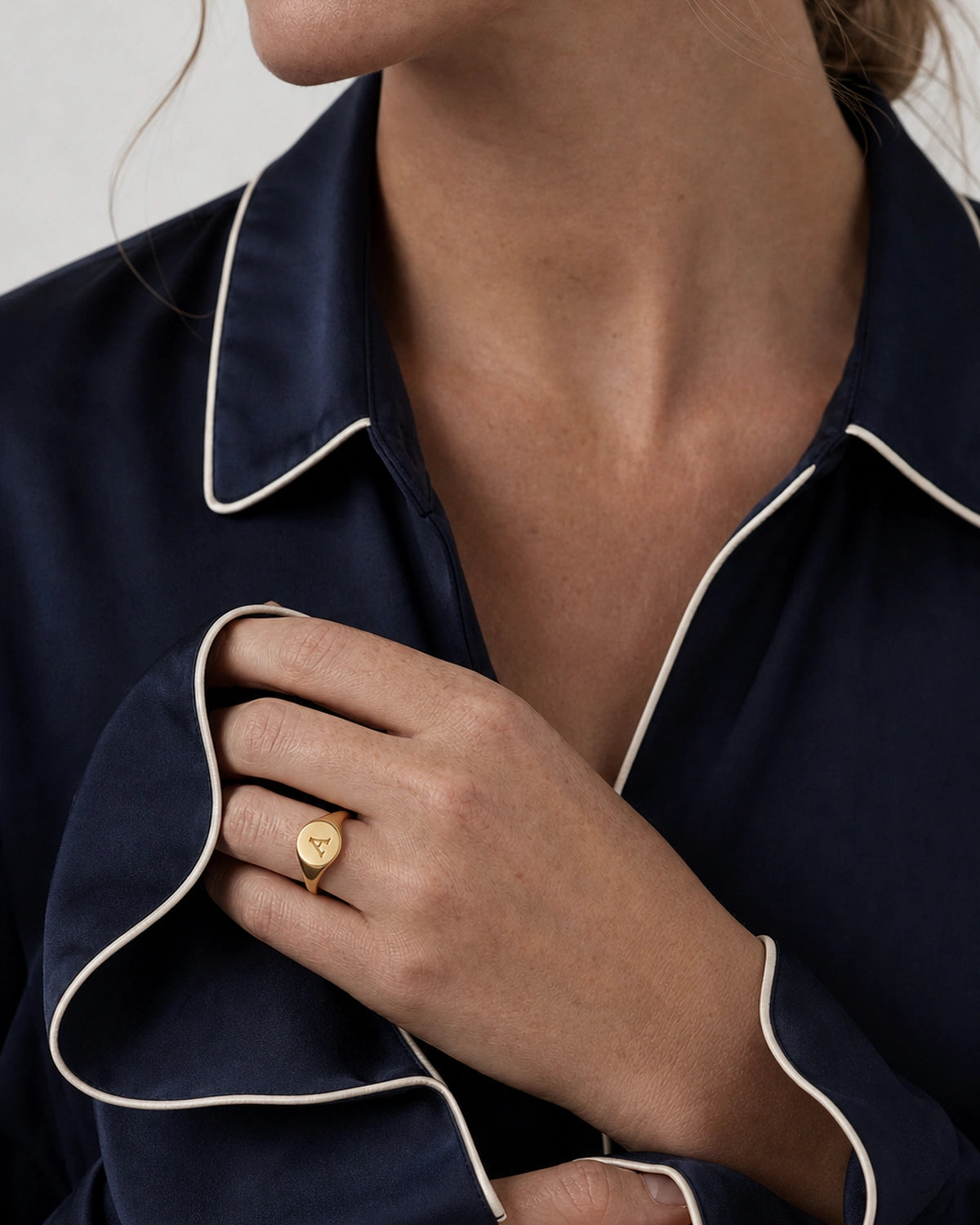 British model gathering a flared navy cuff while wearing the gold Solenne ring