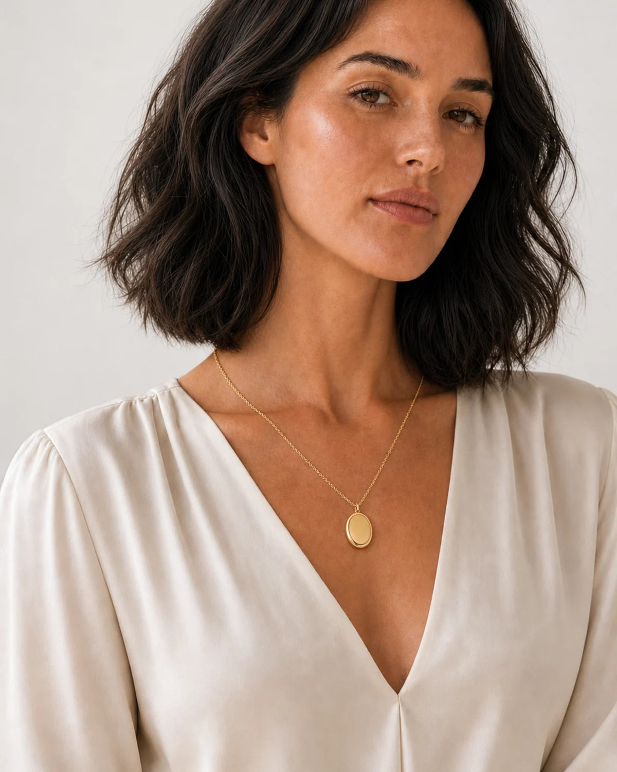 Australian model aged 24 to 28 wearing the Solenne blank oval pendant in a pale dove-grey studio