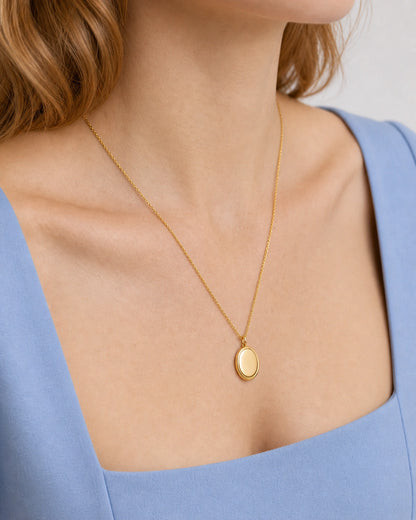 Jewellery-led neckline detail of the gold Solenne pendant on cornflower blue