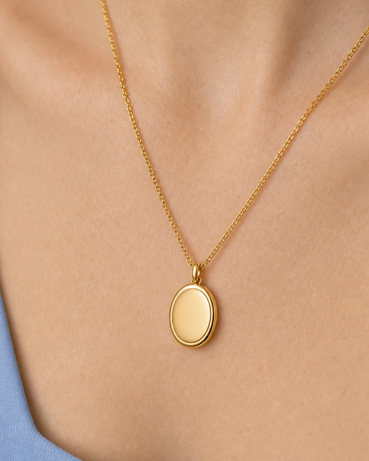 Complete worn macro of the blank polished gold Solenne oval pendant