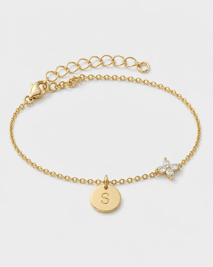 Soline gold initial S and four-stone flower bracelet on pale dove-grey