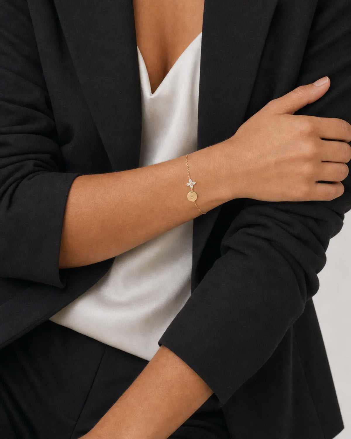 Human-scale wearing detail of the Soline bracelet with black tailoring