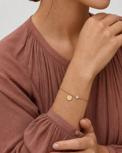 Supported forearm pose wearing the gold Soline initial S bracelet