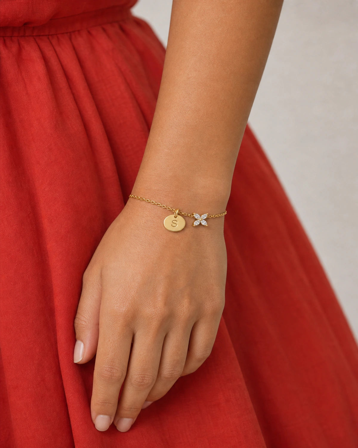 Close wearing view of the Soline engraved S disc and four-stone flower