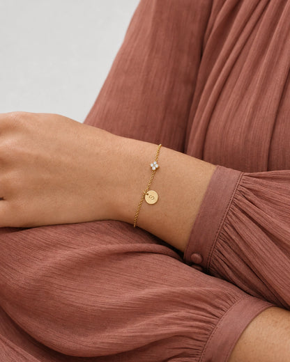 Palm-down sleeve study wearing the gold Soline initial bracelet