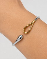 Extreme wrist macro of Sora silver droplet and gold loop terminals