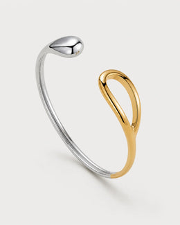 Sora two-tone open bangle on a pale neutral-grey studio background