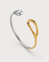 Sora two-tone open bangle on a pale neutral-grey studio background