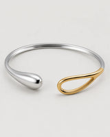 Macro detail of the Sora silver droplet and warm-gold open-loop terminals