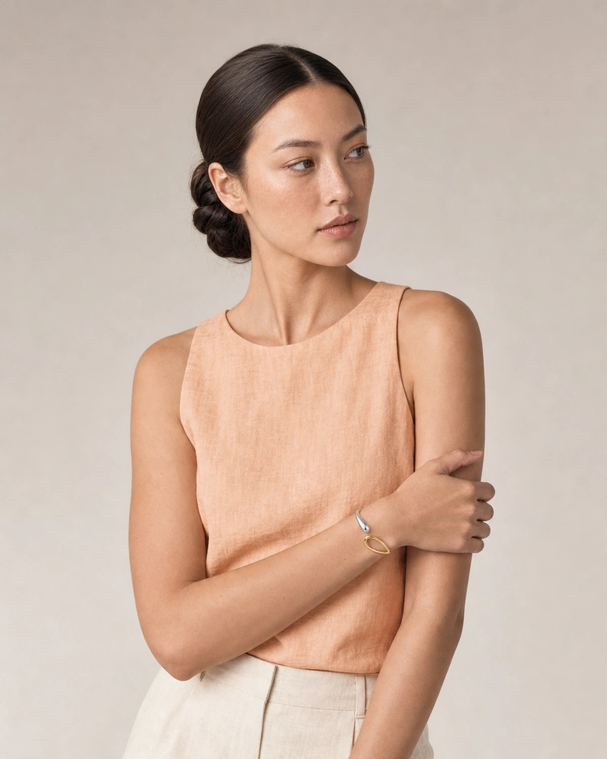 Model in peach and ecru summer linen wearing the Sora two-tone open bangle