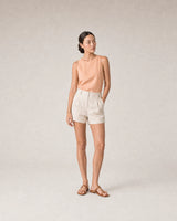 Full-body peach linen summer portrait featuring the Sora bangle