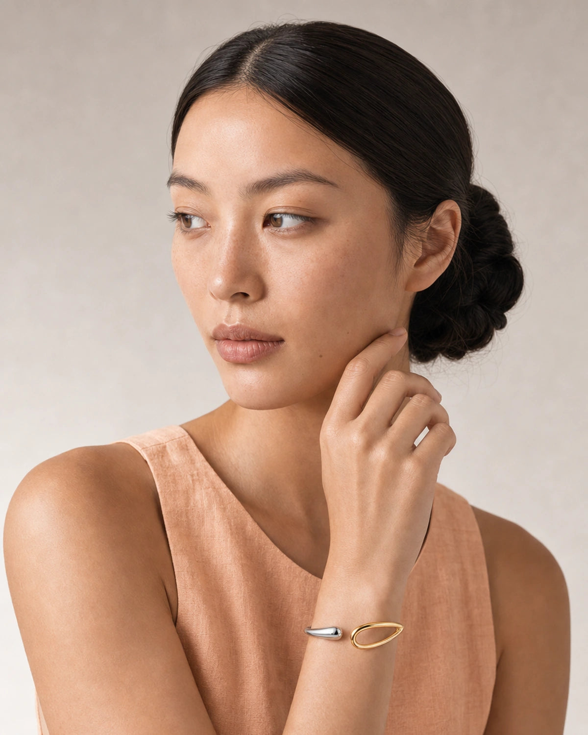 Close wearing view of the Sora silver droplet and gold loop terminals