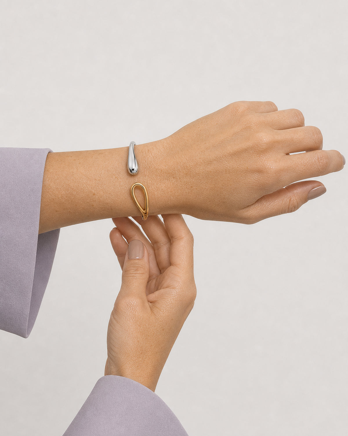 Supported horizontal-wrist view of the Sora mixed-metal open bangle