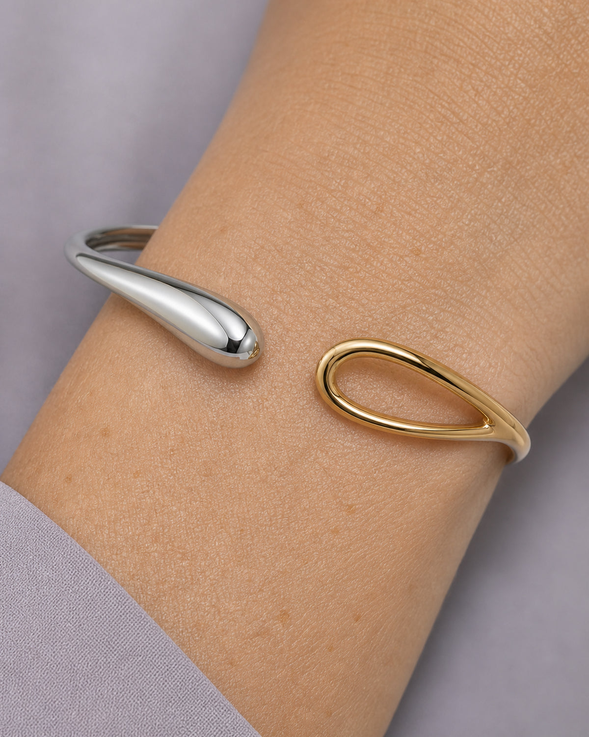 Extreme worn macro of the Sora silver droplet and hollow gold-loop terminals