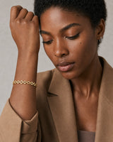 Clean wrist and face close-up of the Talia gold timepiece bracelet worn on model