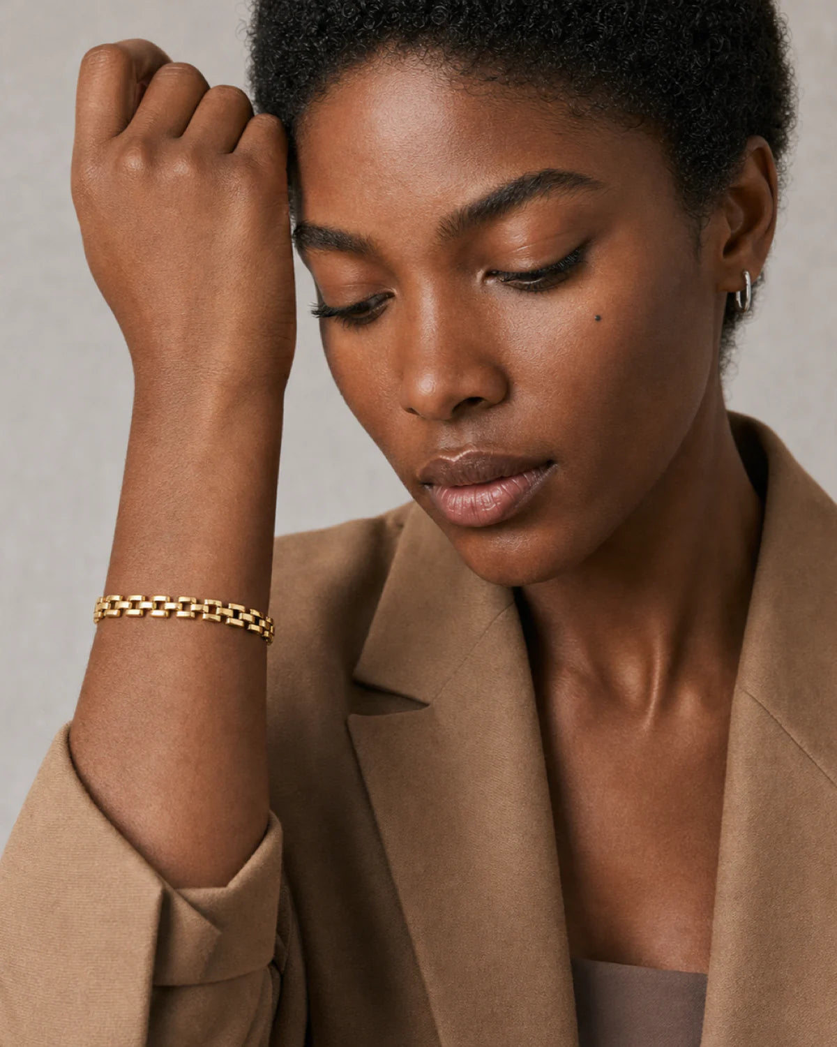 Clean wrist and face close-up of the Talia gold timepiece bracelet worn on model