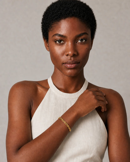 Model in an Amalfi ivory linen halter dress wearing the Talia gold bracelet