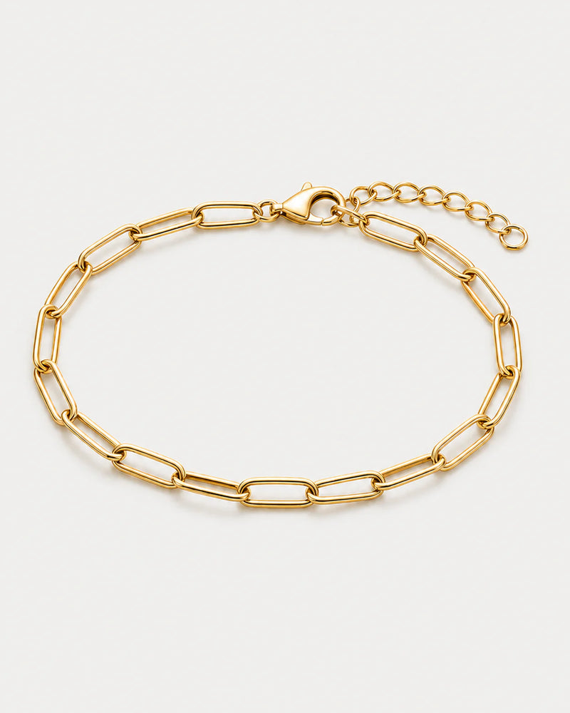 Vela gold paperclip bracelet on pale dove-grey
