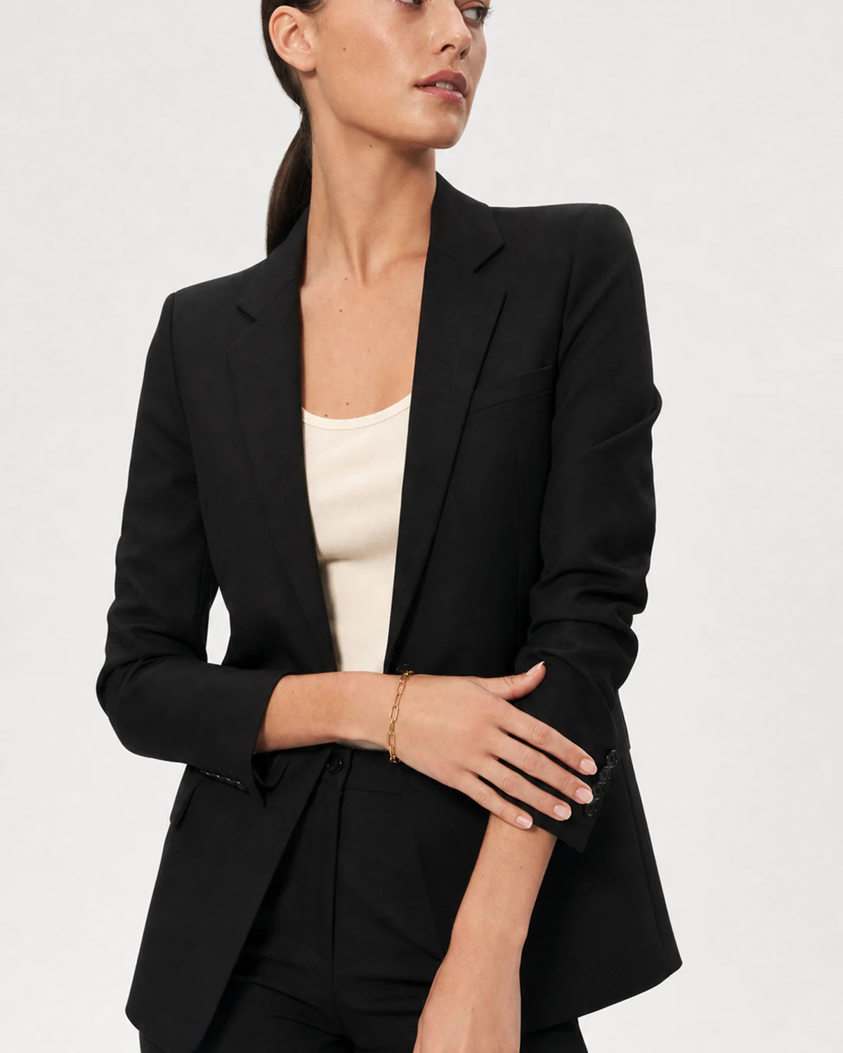 Wide grey-studio portrait featuring Vela paperclip bracelet