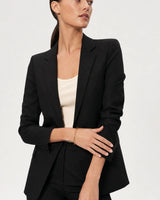 Wide grey-studio portrait featuring Vela paperclip bracelet