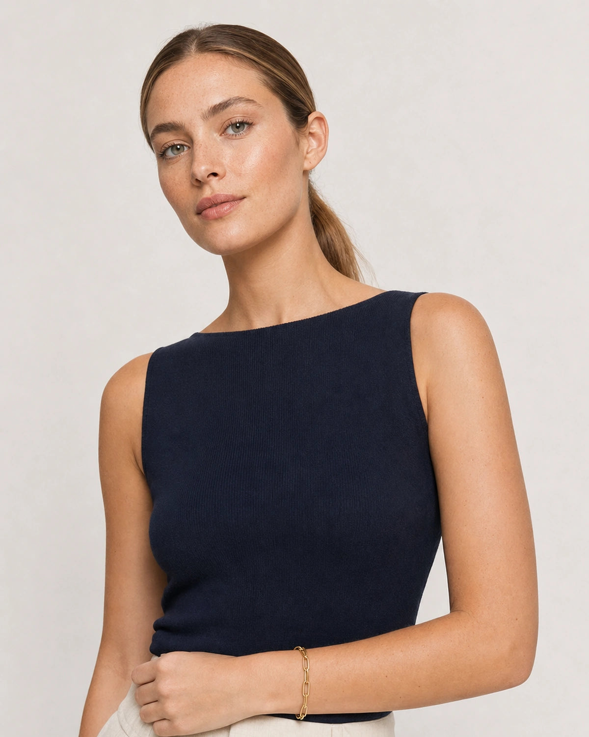 Model in a navy sleeveless Riviera summer top wearing the Vela paperclip bracelet