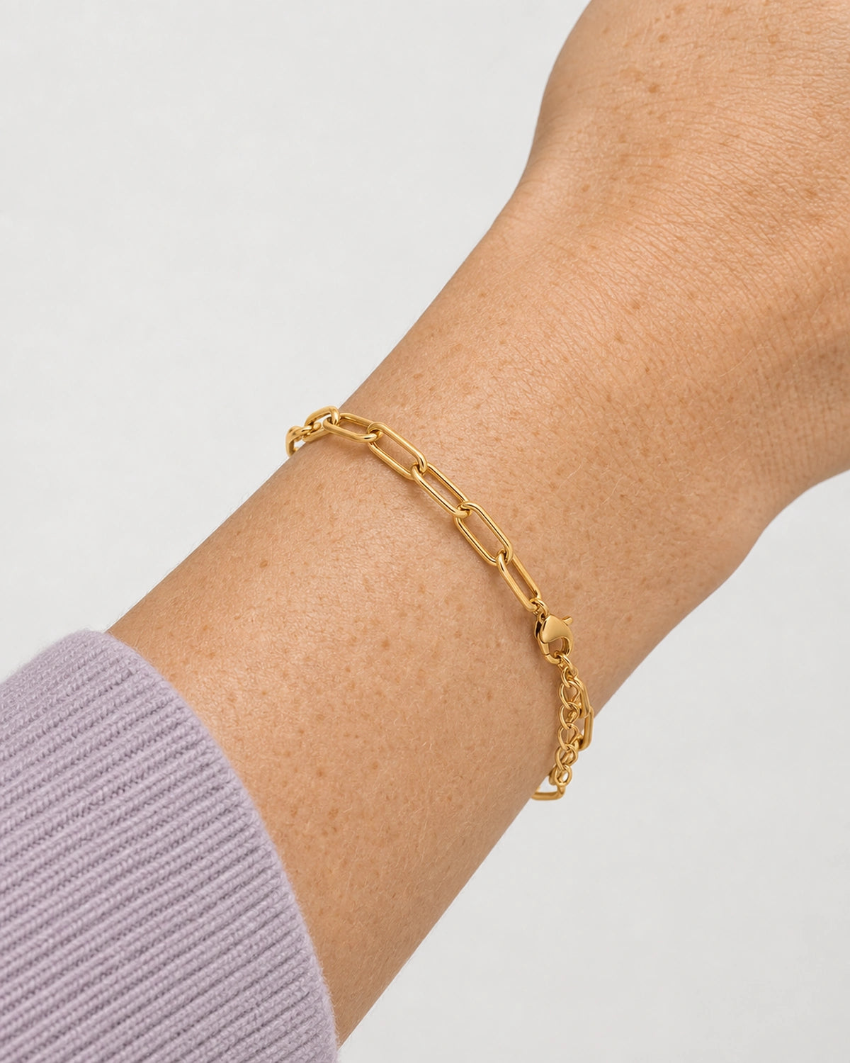 Complete Vela gold paperclip bracelet worn in an extreme wrist macro