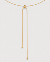 Macro detail of the Vela polished slider and two unequal ball-tipped gold tails
